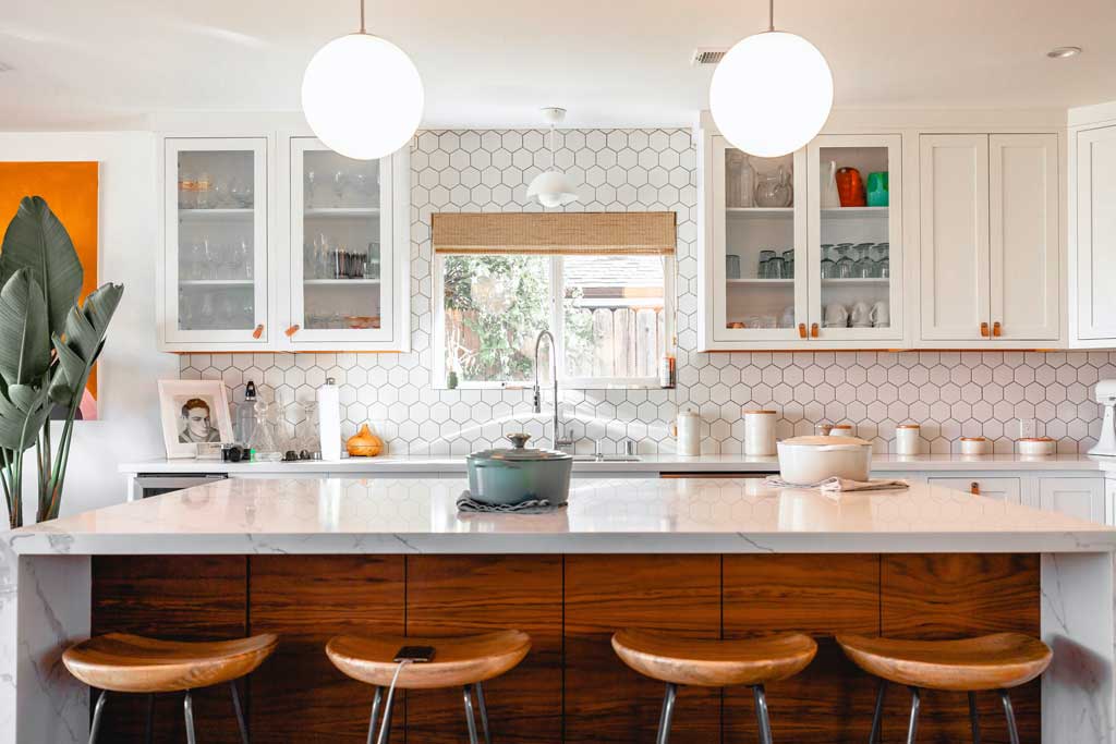 Bright contemporary kitchen with stone countertops and white cabinets.